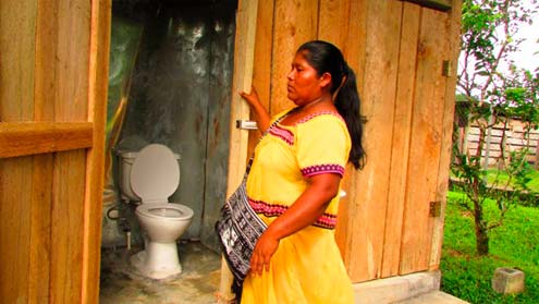 A woman from the Ngäbe-Buglé region of Panama shows the installed toilets